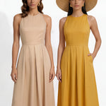 Two professional models wearing elegant halter-neck pleated maxi dresses in khaki and mustard yellow, featuring a high-waist A-line silhouette and side pockets, perfect for a sophisticated summer vacation or garden party look.