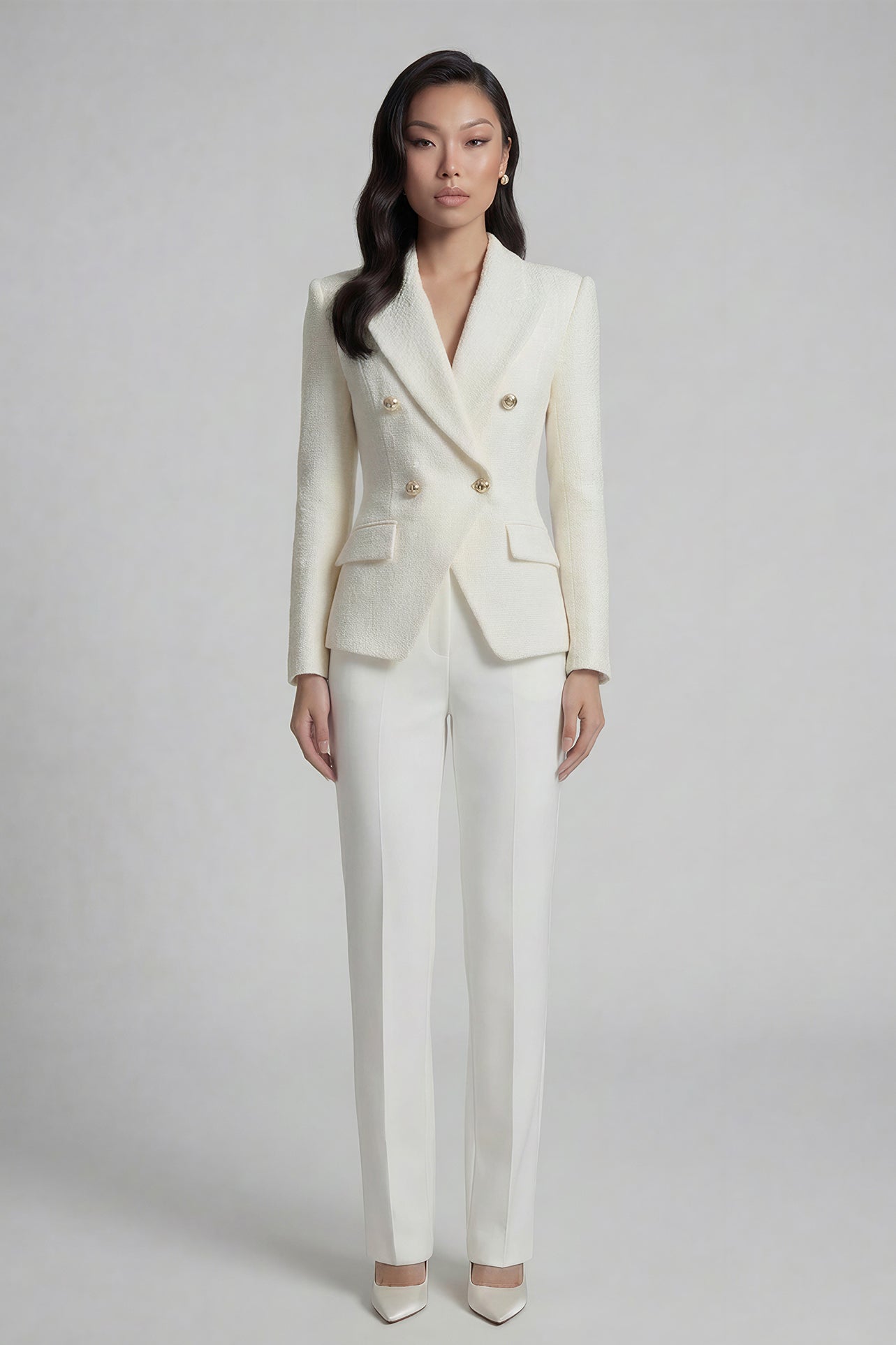 A professional woman wearing a sophisticated cream white double-breasted tweed blazer, featuring elegant gold buttons, a tailored slim fit, and classic flap pockets for a polished executive look.