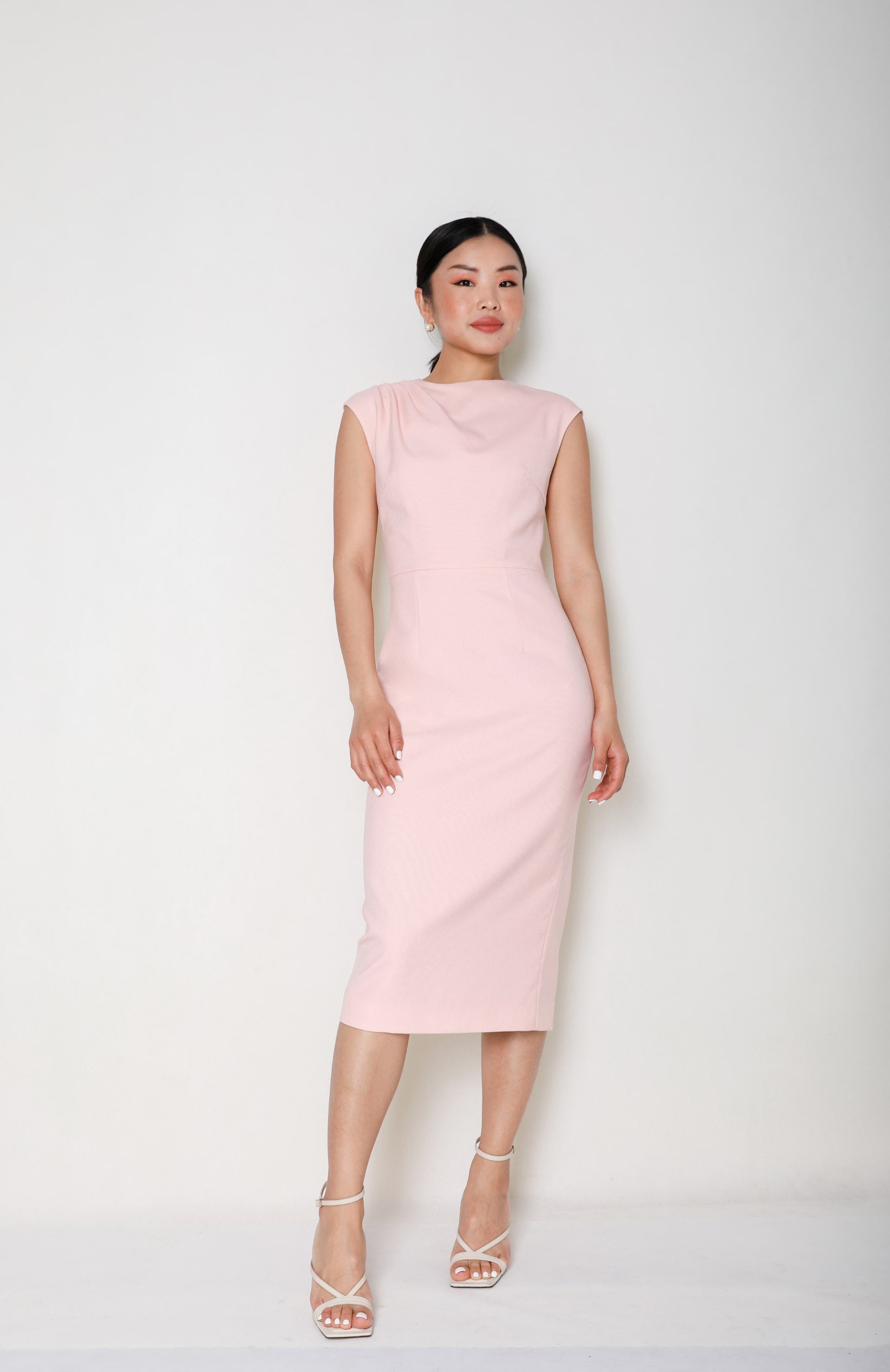 Full-length portrait of Sense By Mei's founder, draped in an elegant pink Cheongsam gown, showcasing the grace and vision of the brand's leadership.