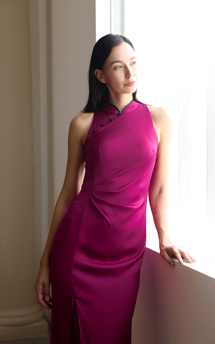 Half-body shot of a model in a soft silk Cheongsam dress by a window, the exclusive BYMEI pink complementing the natural light and emphasizing the dress's elegant, non-fluorescent hue.