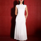 Frontal view of a model in Brand by Mei's white silk mermaid Cheongsam, set against a vibrant red backdrop, highlighting the blend of traditional elegance and modern design.