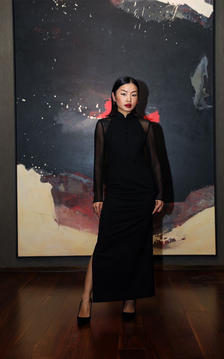 Frontal view of a model wearing a black long-sleeved Cheongsam dress with modern mesh details, embodying a blend of traditional charm and contemporary style.