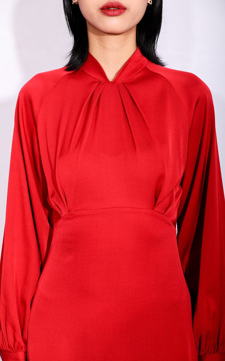 Close-up of the rich red silk fabric of a modern Cheongsam dress, showcasing the soft sheen and premium texture on a white background.