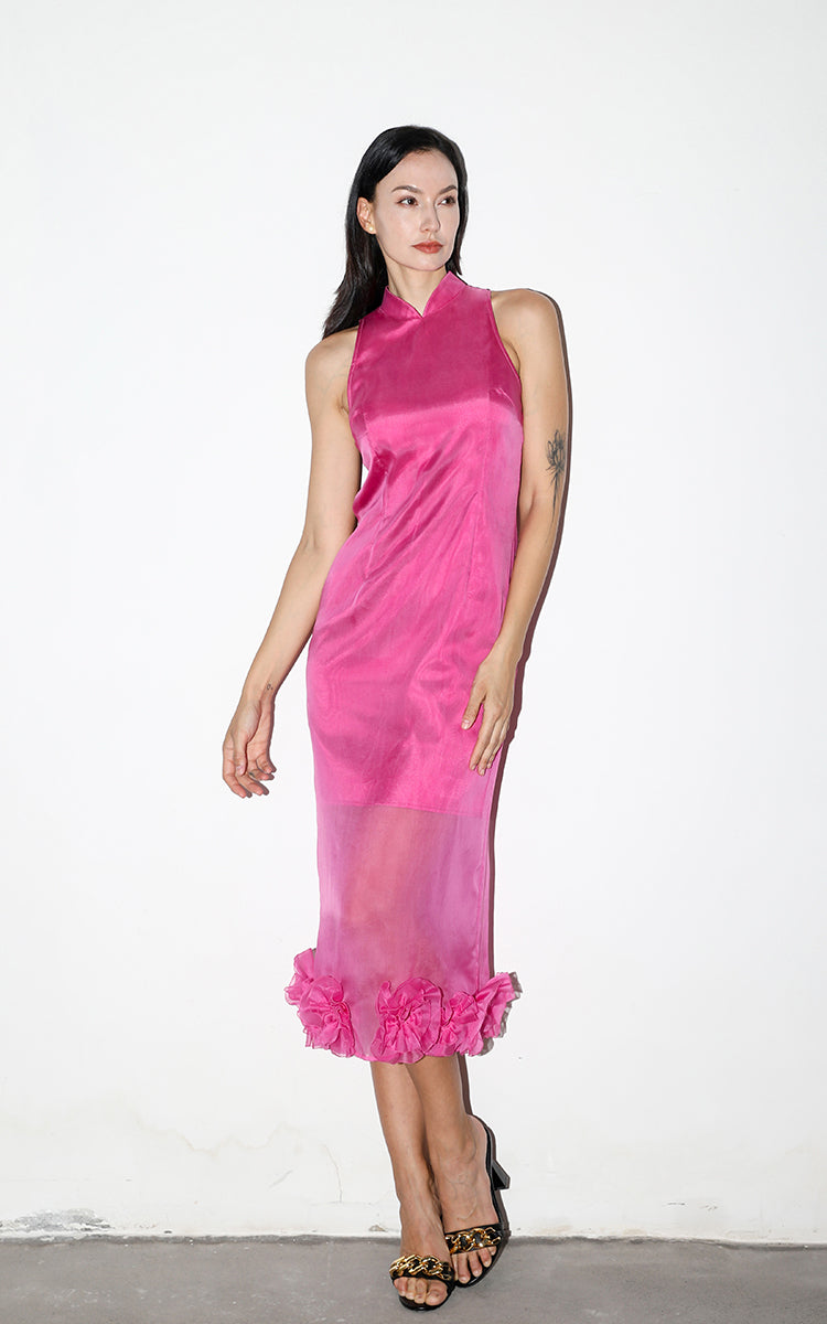 Model posing in a rose red silk organza Cheongsam with floral details, featuring a modern shoulder-cut design, against a white background.