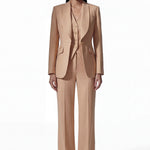 A professional woman wearing a sophisticated apricot-colored tailored vest, featuring a deep V-neckline and a unique pointed hem for an elegant executive office look.