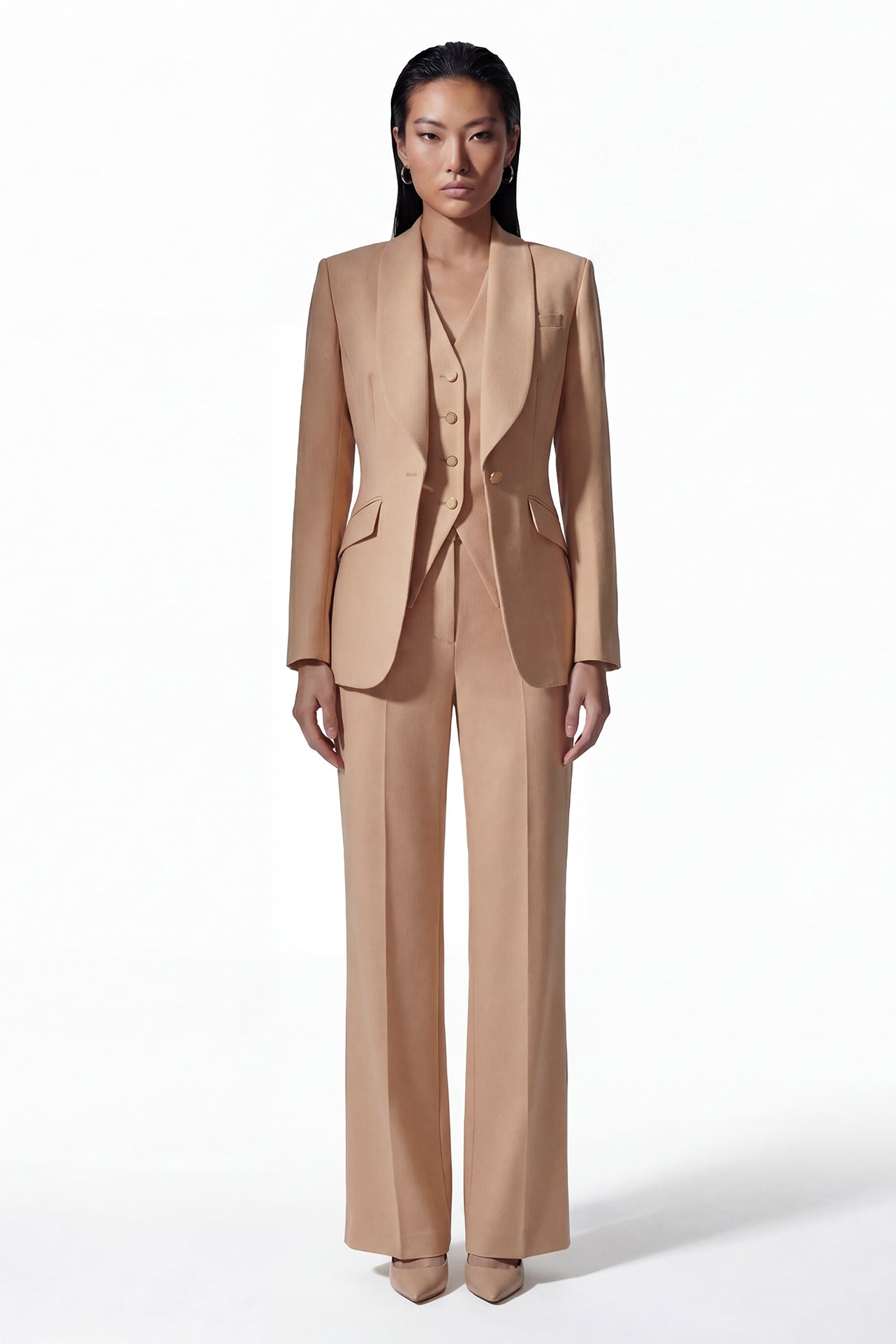 A professional woman wearing a sophisticated apricot-colored tailored vest, featuring a deep V-neckline and a unique pointed hem for an elegant executive office look.