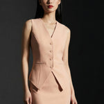 A professional woman wearing a sophisticated apricot-colored tailored vest, featuring a deep V-neckline and a unique pointed hem for an elegant executive office look.