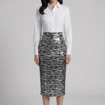 A woman wearing a glamorous high-waisted pencil skirt featuring shimmering silver and black sequins in a stylish zebra print, ideal for an elegant evening party or a night out.