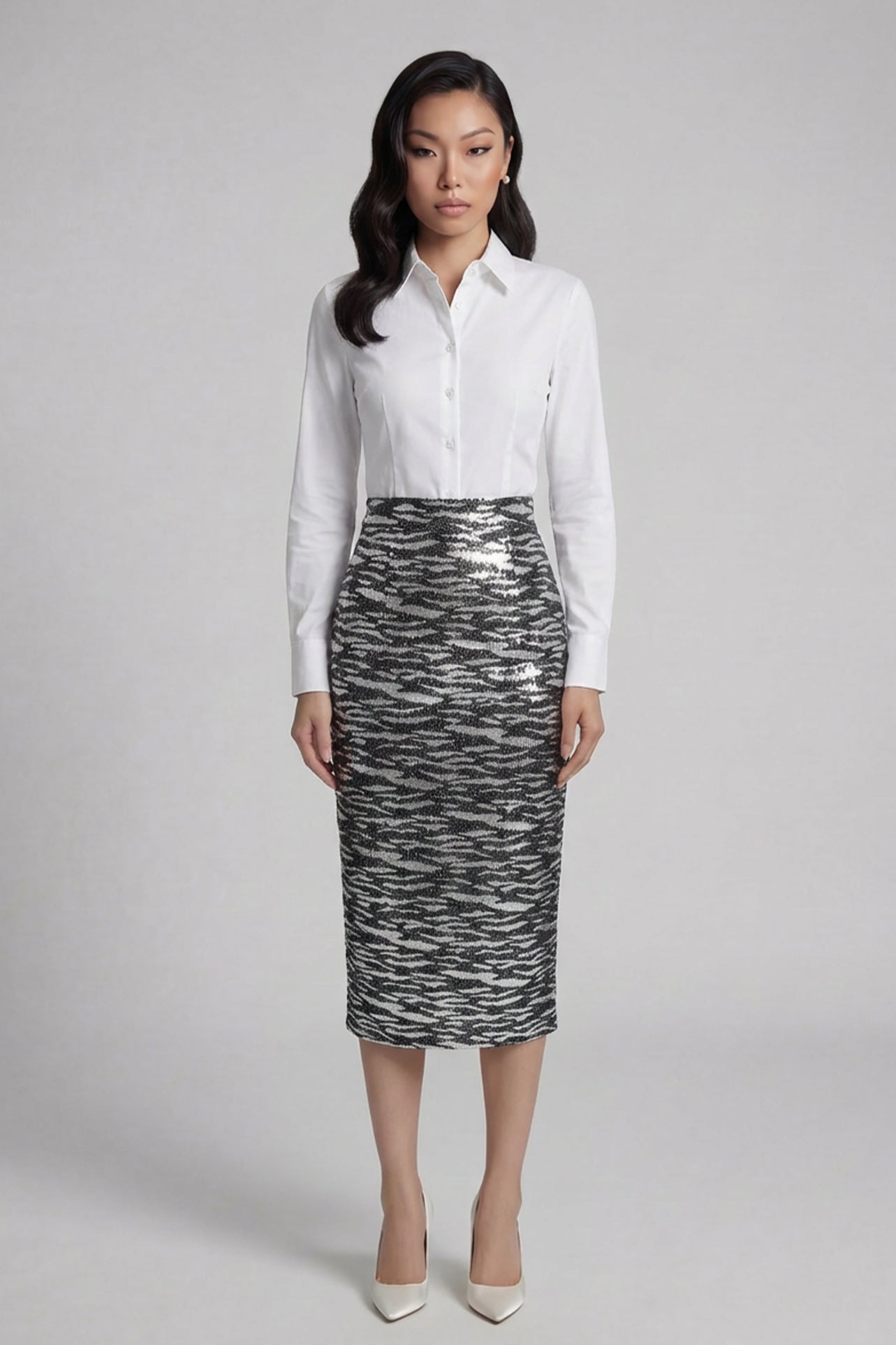A woman wearing a glamorous high-waisted pencil skirt featuring shimmering silver and black sequins in a stylish zebra print, ideal for an elegant evening party or a night out.