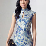 A professional woman wearing a sophisticated modern qipao dress, featuring a blue and white porcelain floral print, a mandarin collar with keyhole detail, and a slimming tailored fit for an elegant executive look.