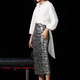 A woman wearing a glamorous high-waisted pencil skirt featuring shimmering silver and black sequins in a stylish zebra print, ideal for an elegant evening party or a night out.