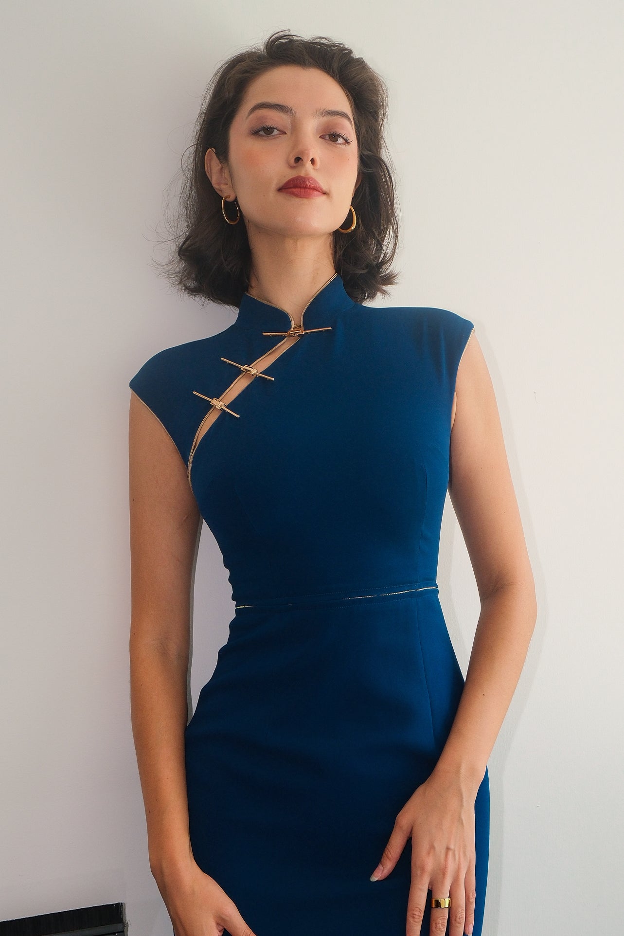 A collection of four professional models of different ages wearing elegant royal blue dresses featuring modern Chinese elements, including mandarin collars, traditional knot buttons, and diverse silhouettes from sleek sheaths to pleated A-line skirts.