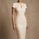 A professional woman modeling a sophisticated blush pink sheath dress, featuring a unique gathered neckline with keyhole detail and a tailored slim fit for a timeless executive look.