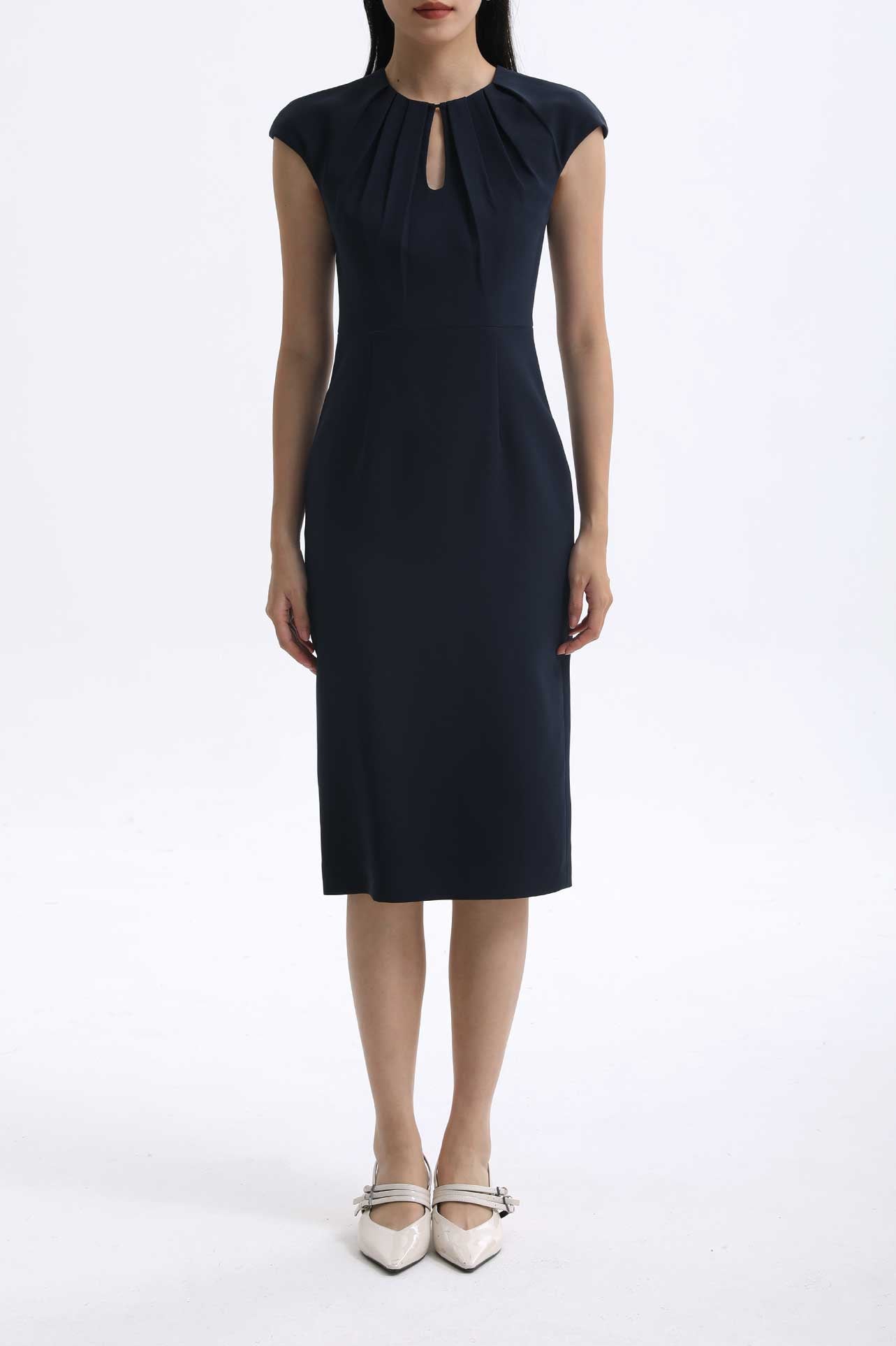 A professional woman wearing a sophisticated navy blue midi dress, featuring an elegant pleated neckline with a subtle keyhole detail and a tailored slim-fit pencil silhouette for a polished executive look.