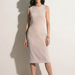 A professional woman modeling an elegant mustard yellow sleeveless sheath dress, featuring a sophisticated crew neckline and a tailored slim fit with princess seams for a polished executive look.