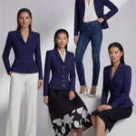 A professional model wearing a sophisticated navy blue tailored blazer with an hourglass silhouette and unique O-ring gold buttons, paired with crisp white trousers for an executive office look.