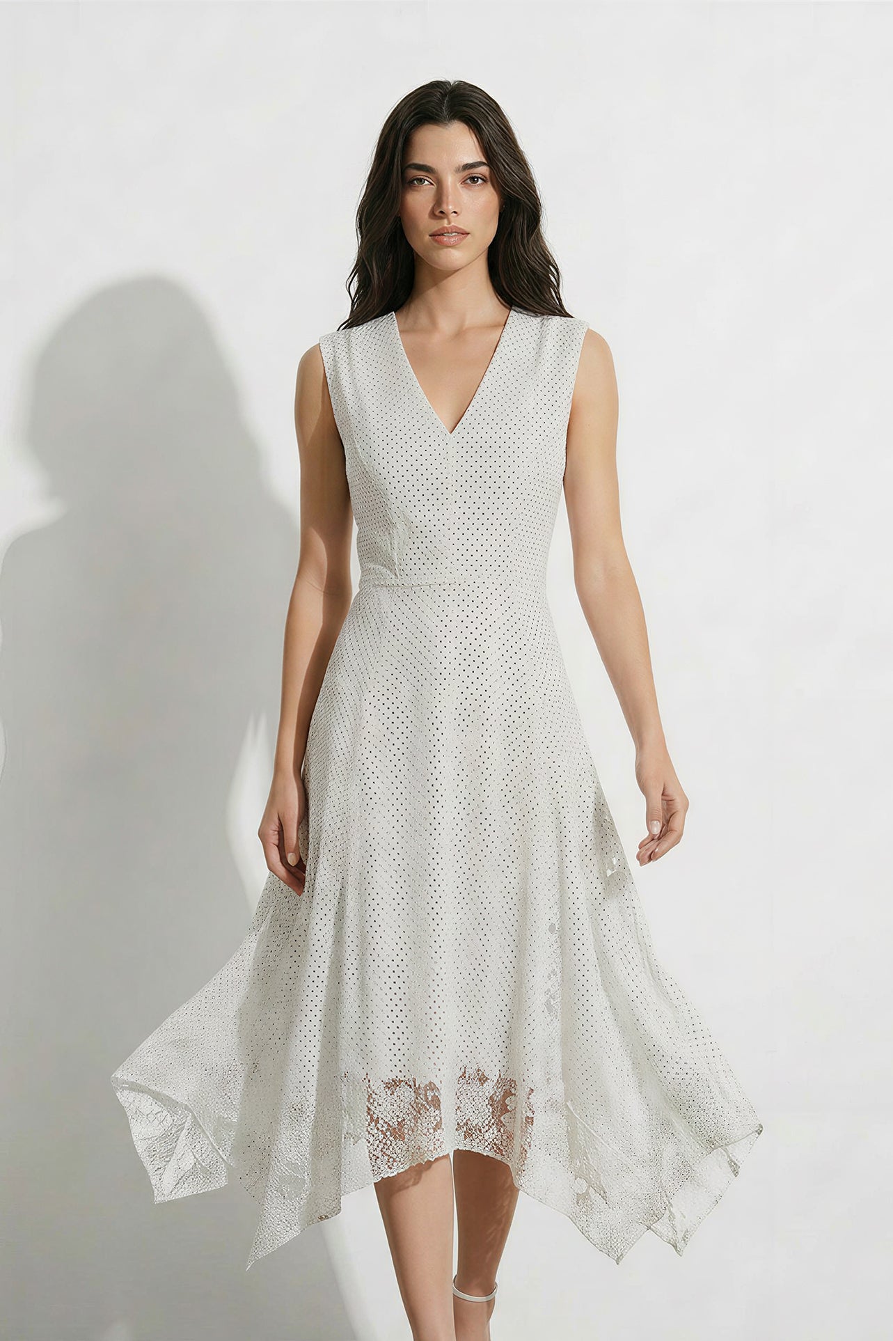 A professional woman modeling an elegant white lace sleeveless dress, featuring a sophisticated V-neckline, a tailored fit-and-flare silhouette, and an intricate hollow-out eyelet texture with a delicate lace trim hem.