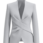 A professional woman wearing a sophisticated light grey tailored suit set, featuring a unique wrap-front blazer with criss-cross waist detailing and matching slim-fit trousers for a polished executive look.