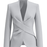 A professional woman wearing a sophisticated light grey tailored suit set, featuring a unique wrap-front blazer with criss-cross waist detailing and matching slim-fit trousers for a polished executive look.
