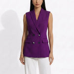 A professional woman modeling an elegant deep purple sleeveless double-breasted blazer vest, featuring a notched lapel, front flap pockets, and a slim belt, paired with white tailored trousers for a sophisticated office look.