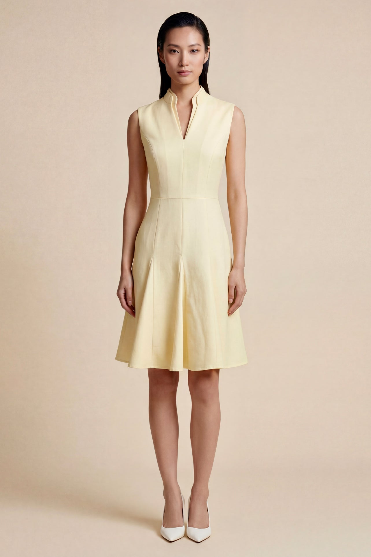 A side-by-side comparison of an elegant pale yellow sleeveless dress in two lengths, featuring a sophisticated mandarin collar, a stylish bow tie-waist, and a pleated A-line skirt for a classic feminine look.