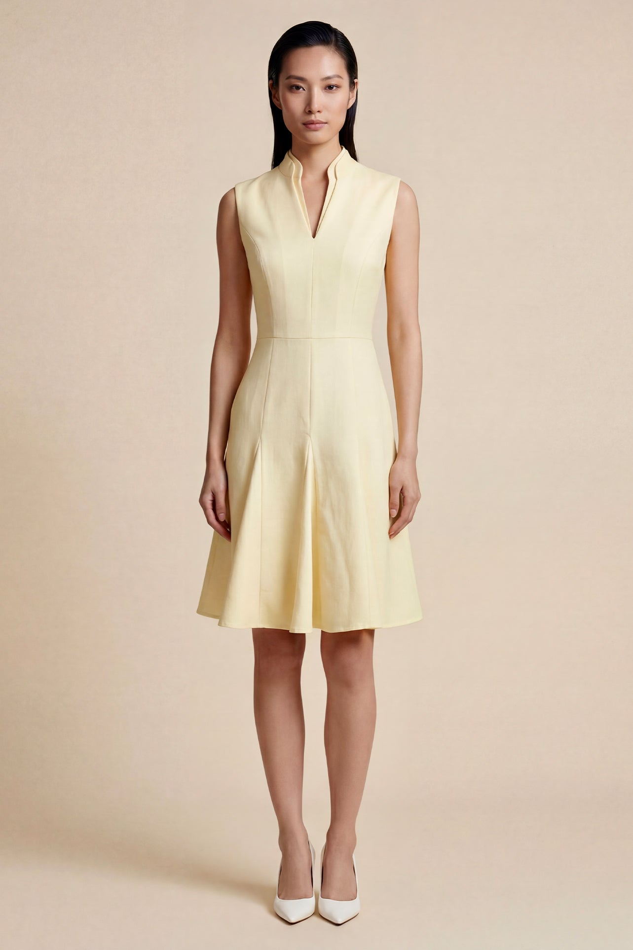 A side-by-side comparison of an elegant pale yellow sleeveless dress in two lengths, featuring a sophisticated mandarin collar, a stylish bow tie-waist, and a pleated A-line skirt for a classic feminine look.