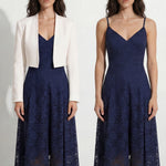 A professional woman modeling an elegant navy blue lace midi dress, featuring delicate V-neck spaghetti straps, a tailored fit-and-flare silhouette, and a beautiful flowing asymmetric handkerchief lace trim hem.