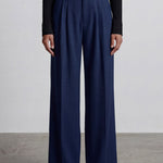 Comparison of elegant navy blue and ivory cream high-waisted wide-leg trousers, featuring sophisticated pleated front details and a tailored relaxed fit for professional office wear.