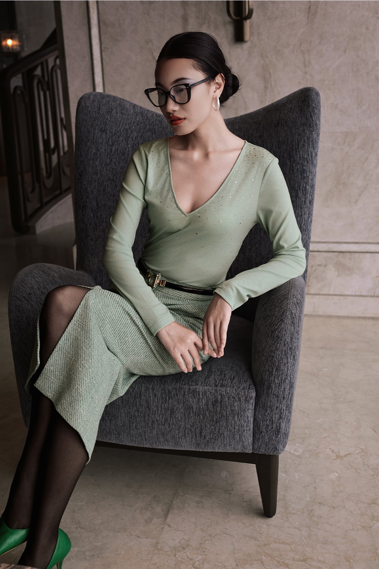 A style comparison of two elegant women's long-sleeve deep V-neck tops featuring subtle rhinestone crystal embellishments; shown on the left in nude camel tucked into tailored trousers, and on the right in pale mint green styled with a white skirt.