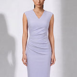A style comparison of two elegant professional midi dresses with short cap sleeves; the left showcasing a sophisticated teal blue tailored sheath dress with a V-neckline and refined side ruching, and the right featuring the same slimming draping design in a soft pastel lavender lilac color.