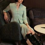 A woman wearing an elegant high-waisted mint green textured pencil midi skirt featuring a clean front waistband and a sophisticated front center slit for a refined corporate chic look.