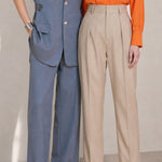 A style comparison of two elegant tailored two-piece suit sets featuring longline sleeveless blazer vests with notched lapels and matching cuffed wide-leg trousers; the left shown in slate blue and the right in sophisticated oatmeal beige.