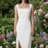 Two professional models wearing elegant square-neck sheath dresses in crisp white and vibrant mid-blue, featuring a tailored slim fit, a front slit, and a functional side pocket for a sophisticated office or social look.