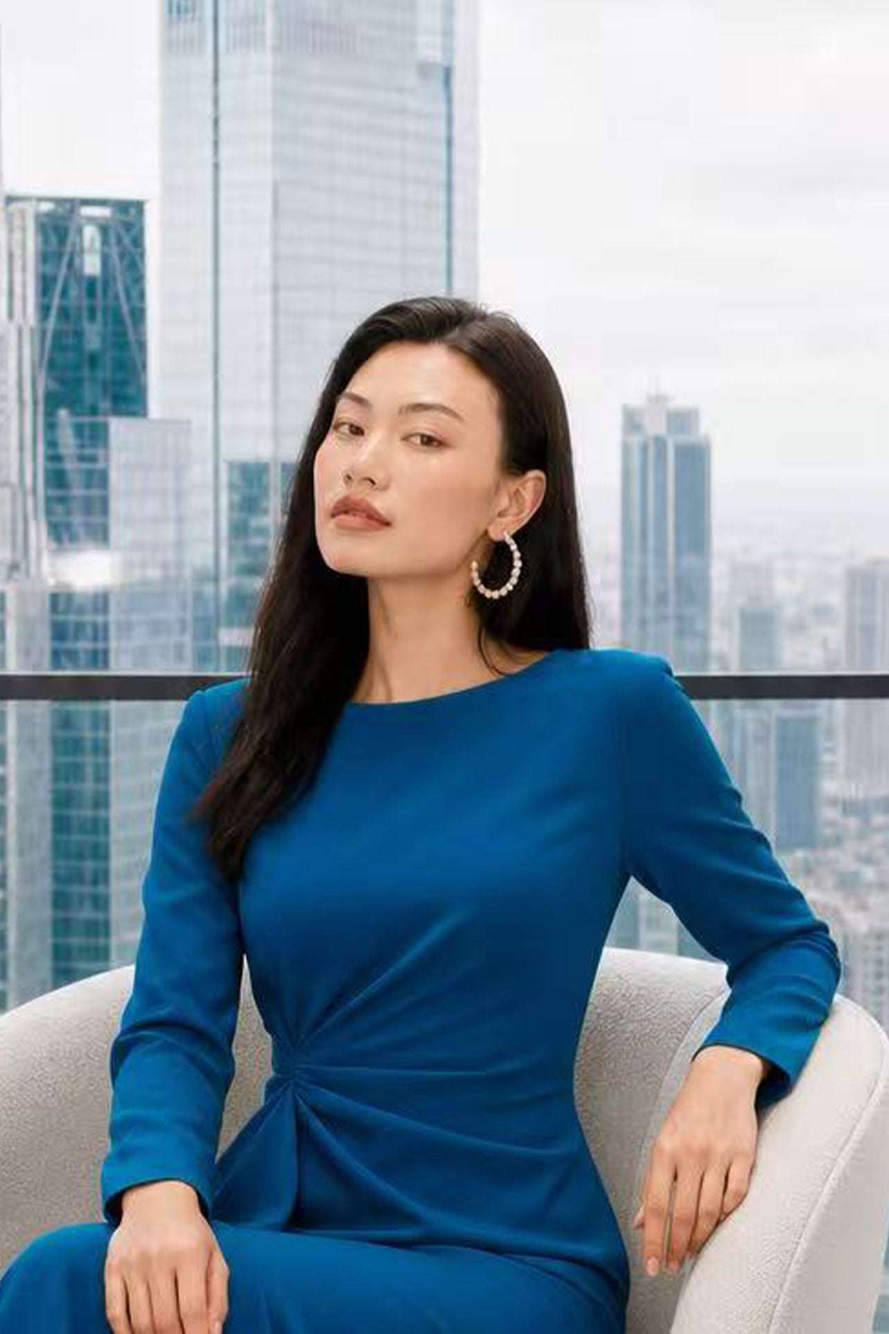 A style comparison of two elegant tailored long-sleeve midi dresses with side twist knotting and cascading ruffles; the left in a sophisticated light dove grey and the right in a vibrant royal blue