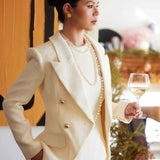 A professional woman wearing a sophisticated cream white double-breasted tweed blazer, featuring elegant gold buttons, a tailored slim fit, and classic flap pockets for a polished executive look.