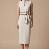 A professional woman modeling an elegant white sleeveless midi dress, featuring a sophisticated stand collar with a V-neck slit and a chic brown contrast bow belt for a polished office look.