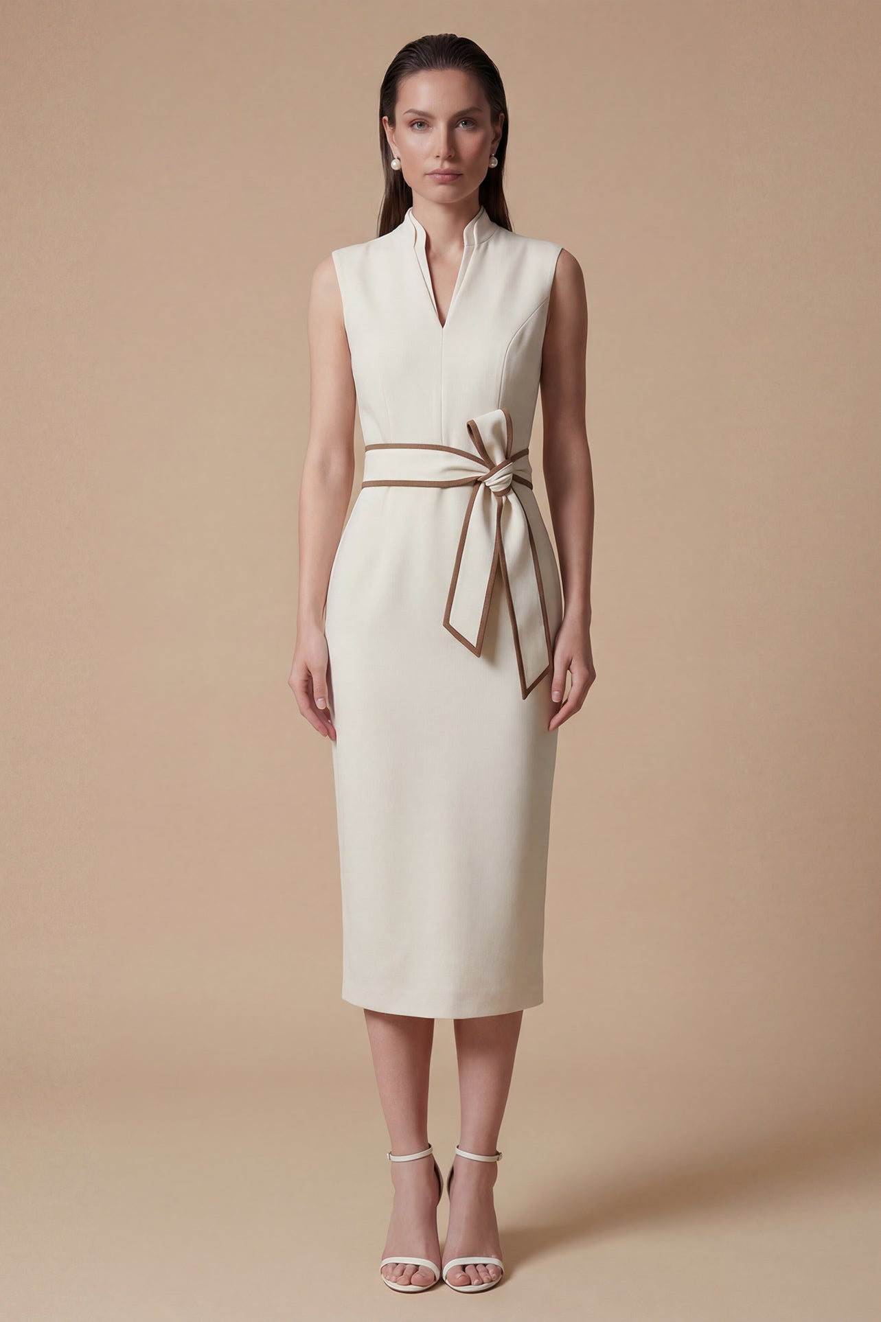 A professional woman modeling an elegant white sleeveless midi dress, featuring a sophisticated stand collar with a V-neck slit and a chic brown contrast bow belt for a polished office look.