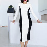 A professional woman wearing a sophisticated black and white color-block midi dress, featuring slimming side panels, long sleeves, and an elegant black belt with a gold buckle for a modern executive office look.