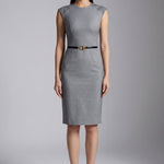 A professional woman wearing a sophisticated grey sleeveless sheath dress, featuring a tailored slim-fit silhouette and an elegant thin black belt with a gold buckle for a polished executive office look.
