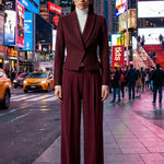 A professional woman wearing a sophisticated burgundy blazer suit with a classic shawl lapel and a white turtleneck, perfect for a high-end executive office look.