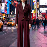 A professional woman wearing a sophisticated burgundy blazer suit with a classic shawl lapel and a white turtleneck, perfect for a high-end executive office look.