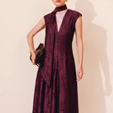 A chic woman wearing sunglasses and an elegant deep burgundy sleeveless V-neck A-line midi dress featuring textured jacquard fabric, delicate lace hemline, and a matching flowing neck scarf.