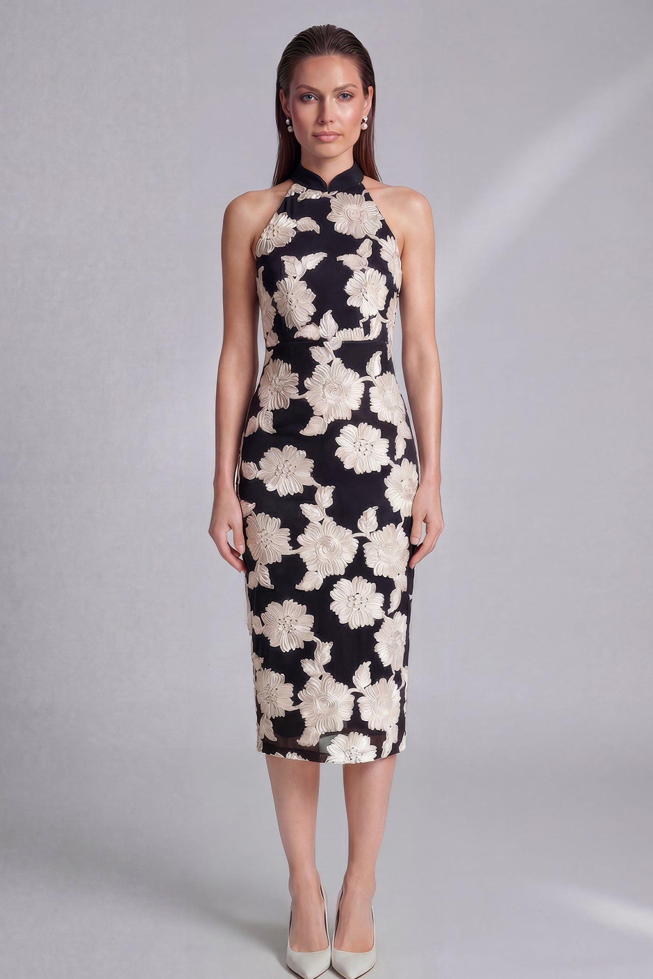 A professional woman wearing a stunning black sleeveless qipao-inspired dress, featuring a chic halter neck with a traditional mandarin collar and large elegant white floral embroidery for a modern oriental evening look.