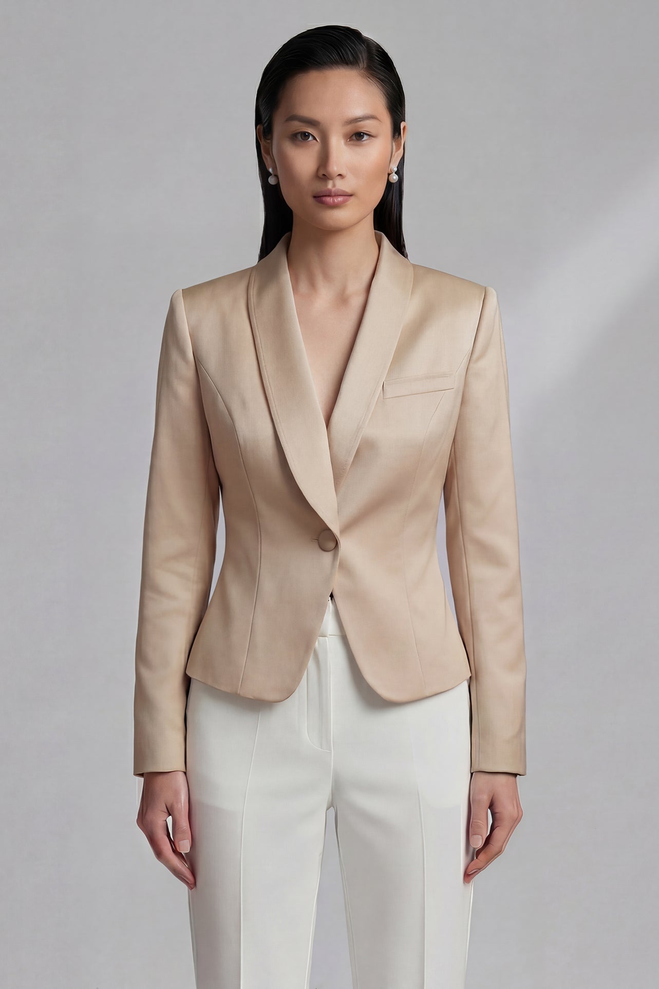 A professional woman wearing an elegant champagne-colored satin blazer with a sophisticated shawl collar and tailored waist, styled for a luxury business or evening event.