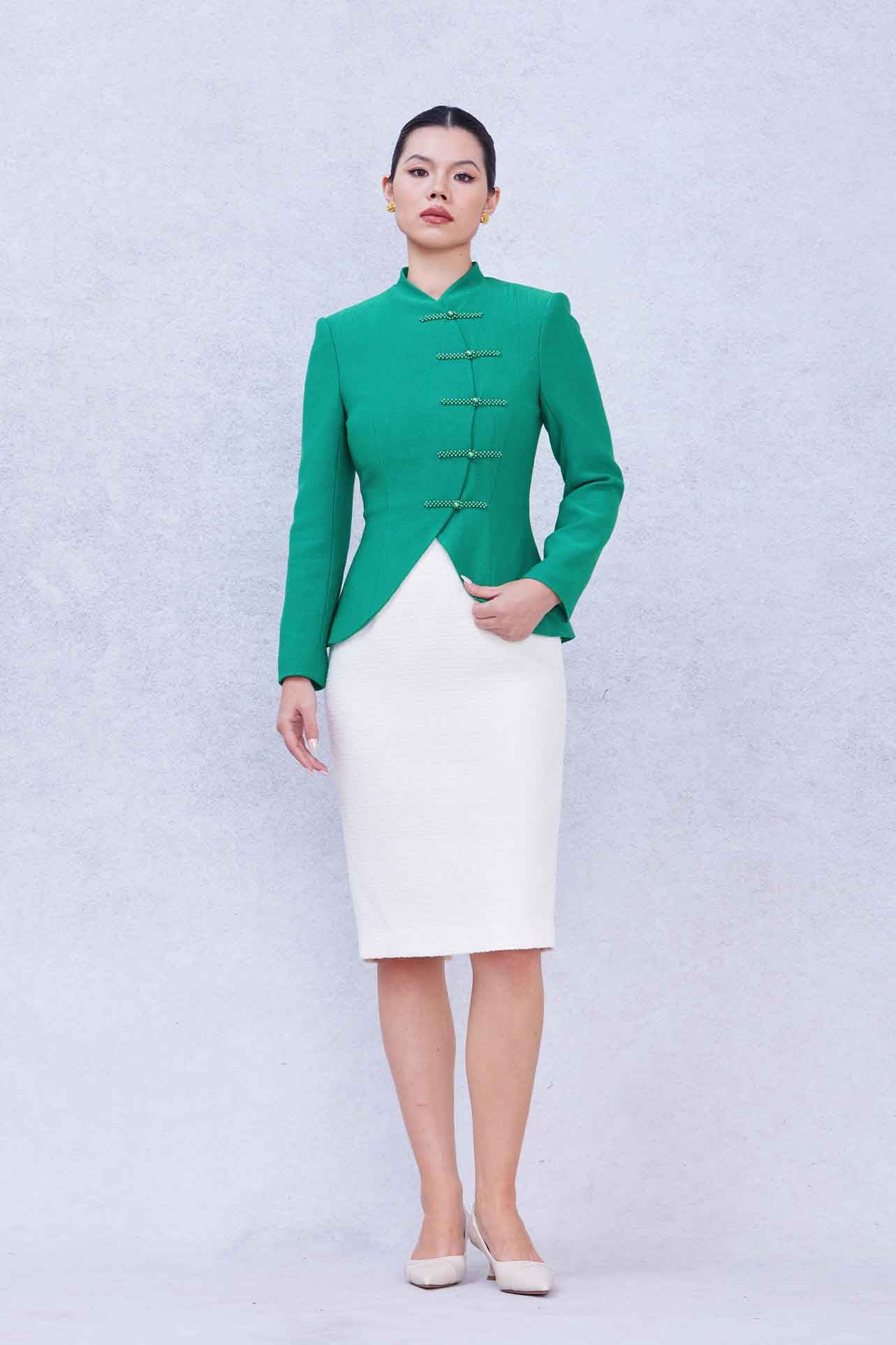 A professional woman wearing a stunning vibrant green blazer, featuring a traditional mandarin collar and elegant frog button detailing for a modern oriental-inspired executive look.