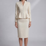 A professional woman wearing a sophisticated cream tweed skirt suit, featuring a tailored jacket with a modern front zipper and an elegant stand collar for a polished executive office look.
