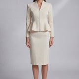 A professional woman wearing a sophisticated cream tweed skirt suit, featuring a tailored jacket with a modern front zipper and an elegant stand collar for a polished executive office look.