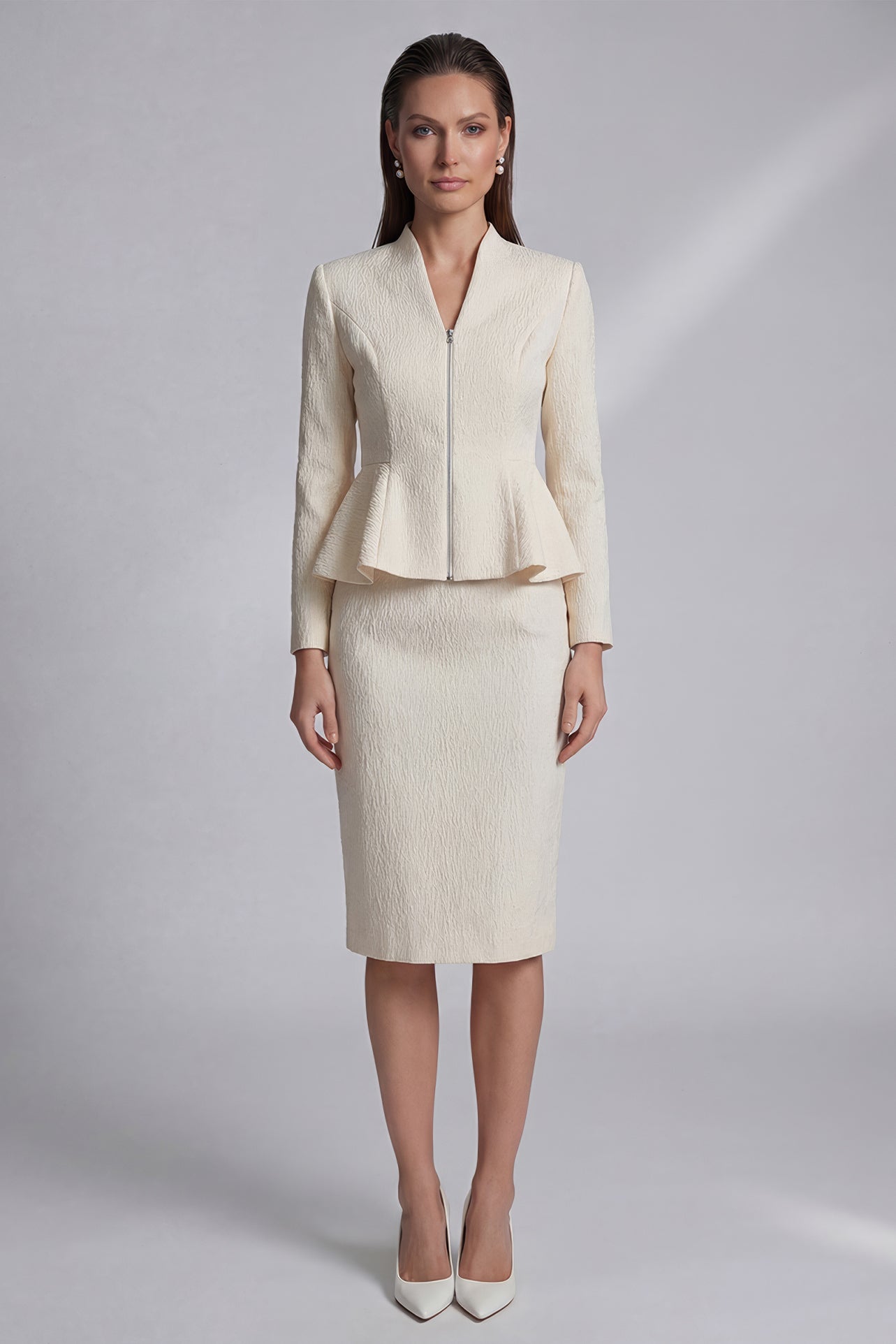 A professional woman wearing a sophisticated cream tweed skirt suit, featuring a tailored jacket with a modern front zipper and an elegant stand collar for a polished executive office look.