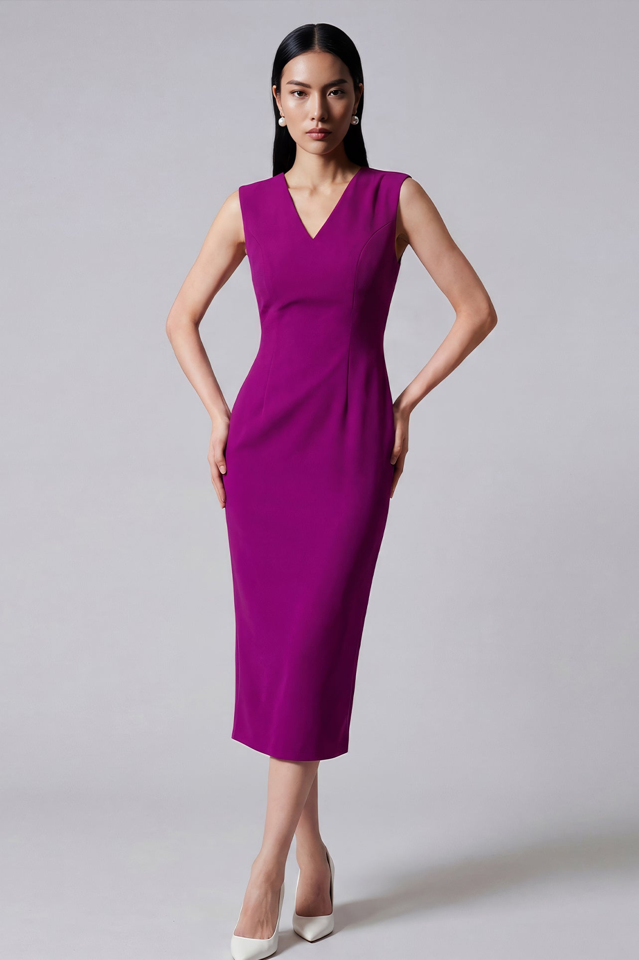 A professional woman wearing a sophisticated magenta v-neck sleeveless midi dress, featuring a tailored slim-fit pencil silhouette for a polished executive office or cocktail look.