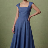 A professional woman modeling an elegant mid-blue midi dress featuring a classic square neckline, cap sleeves, and a flattering A-line flare skirt, perfect for both business and social occasions.